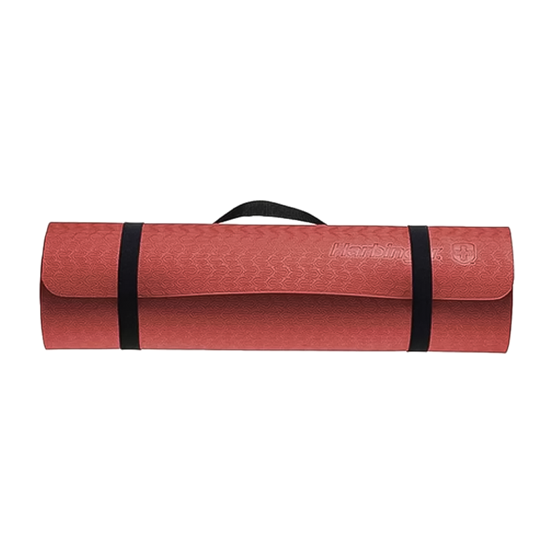 A red yoga mat with black straps, textured surface, and ribbed bottom, made from 100% recycled foam.