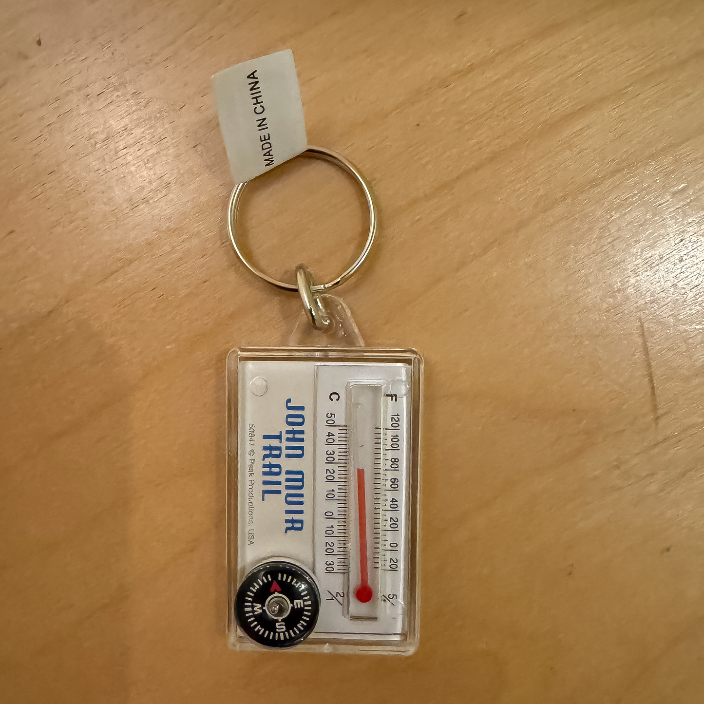 Keychain featuring a mountain range design, compass, and thermometer, inspired by the John Muir Trail for outdoor enthusiasts.