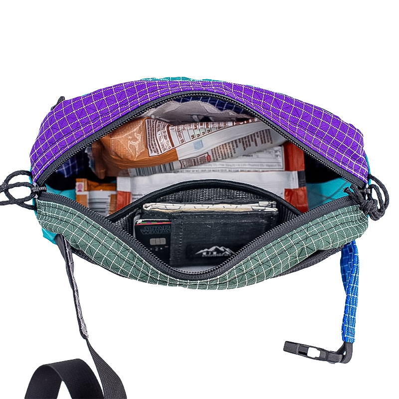 Compact multi-colored ULA waist pack with zipper and strap for outdoor use.