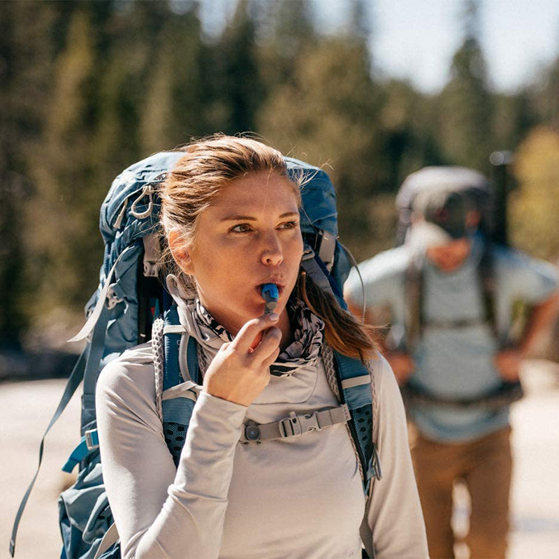 A woman with a backpack shows Hydrapak Bite Valve Sheath, equipped for a trail adventure.