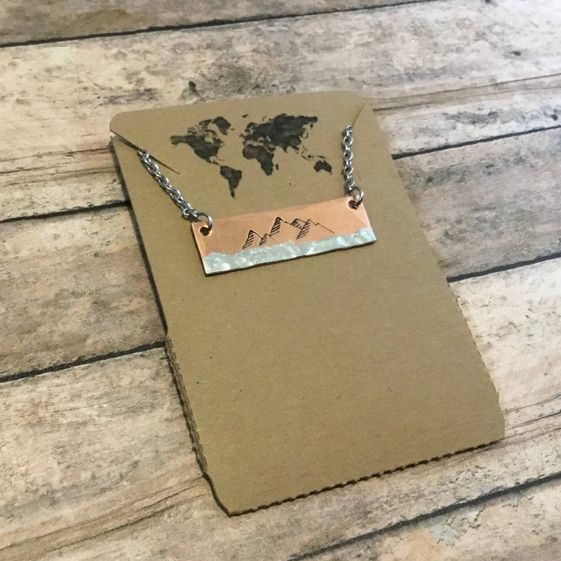 Hand-stamped copper necklace with a mountain design, suspended on a durable 18-inch stainless steel chain.