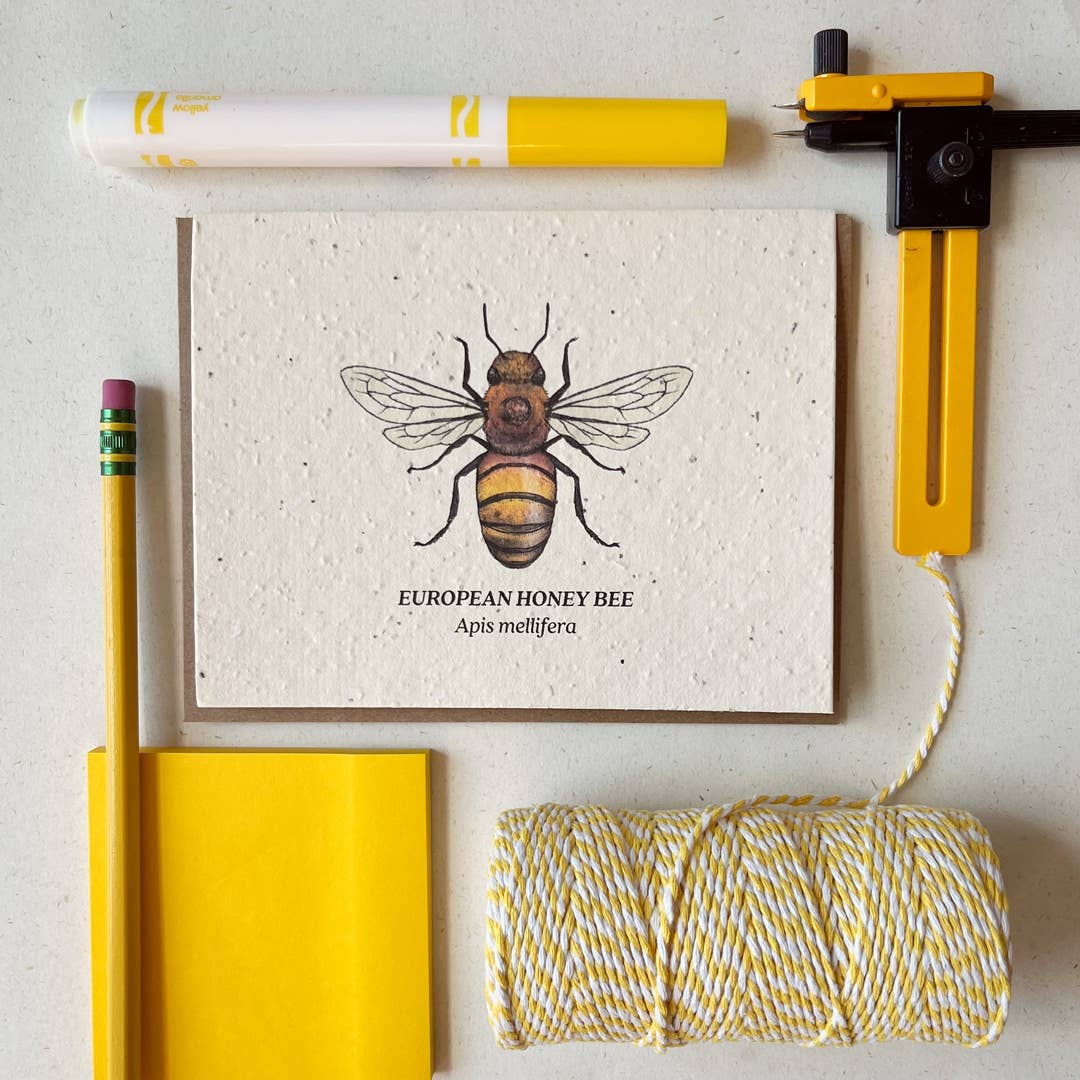 a plantable card depicting a european honey bee surrounded by yellow office supplies