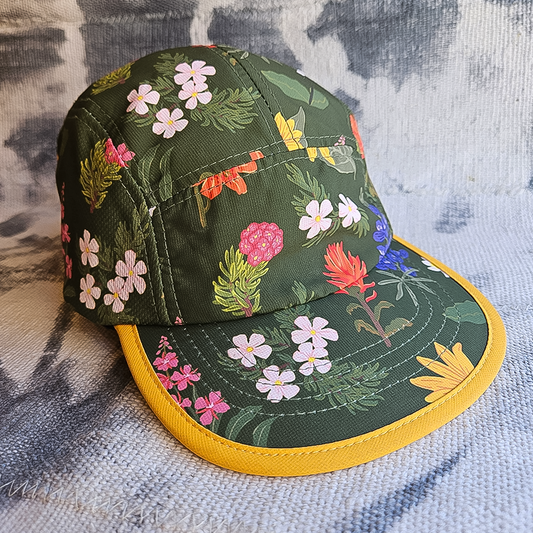 Green running hat with vibrant wildflower print, featuring moisture-wicking fabric and adjustable strap for trail runners.