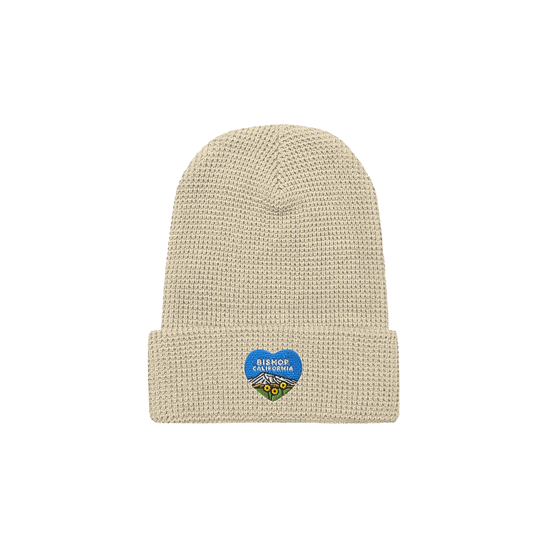 Blue heart design on a beige cozy waffle-knit beanie, perfect for warmth and style in cold weather adventures.
