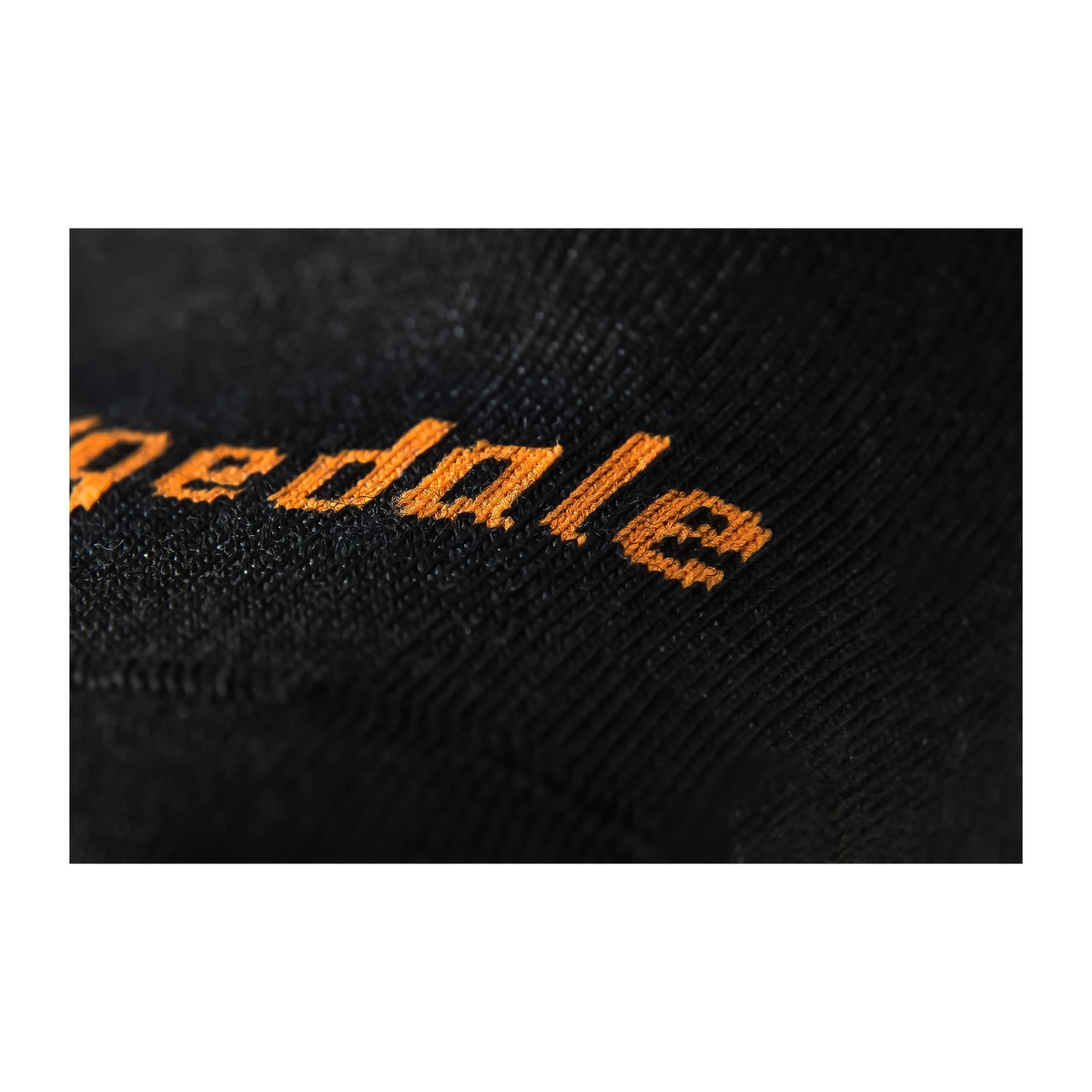 Close-up of the Bridgedale logo on a black ski sock, showcasing its high-performance design for alpine skiing.