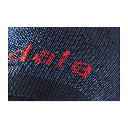 Close-up of the brand Bridgedale on a navy blue sock, showcasing the fabric texture and color of the Bridgedale liner socks.