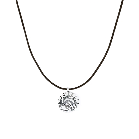 A lightweight sun and mountain charm necklace, ideal for everyday and water-friendly wear.