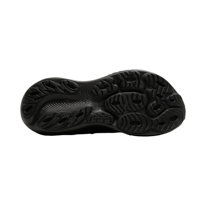 Close-up of a black shoe sole on a white background, highlighting its tread pattern and cushioning technology.