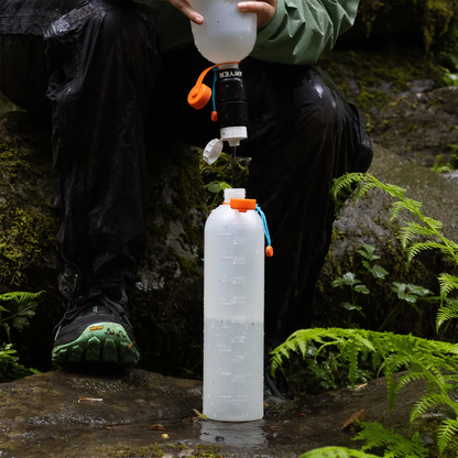 A person fills a CNOC ThruBottle 1000 with water, showcasing its slim design and compatibility with water filters.