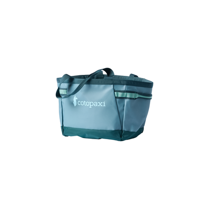 Large blue green tote bag labeled "cotopaxi," designed for carrying gear, featuring durable, water-resistant materials.