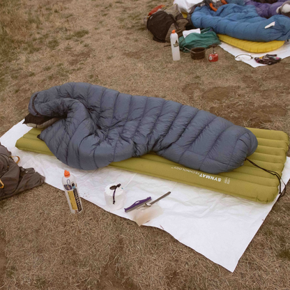 A sleeping bag on top of the Cowboy Camping Claim Jumper groundsheet laid on the ground protecting it from dirt and moisture.