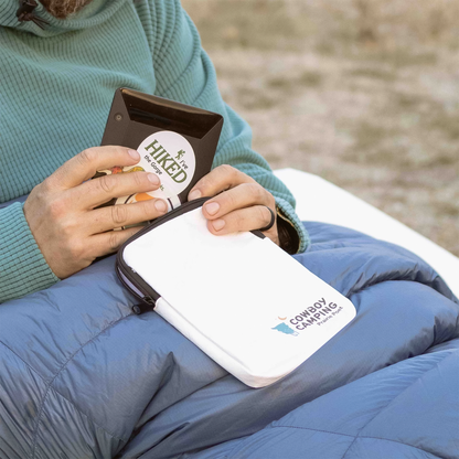 A woman holding an e-reader and a Cowboy Camping Prairie Poet e-reader cover together.