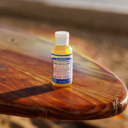 A bottle of Dr. Bronner’s Peppermint Liquid Soap on a wooden table, showcasing its eco-friendly packaging.