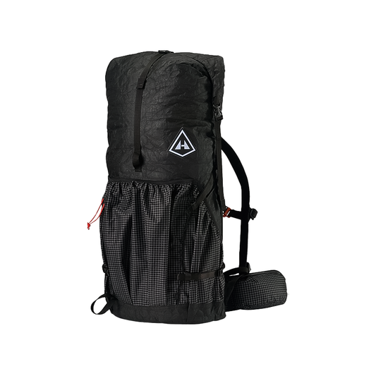 A black Hyperlite Mountain Gear Southwest Pack 55L hiking backpack with a roll-top closure, mesh front pocket, side straps, padded hip belt, and a triangular logo on the front.