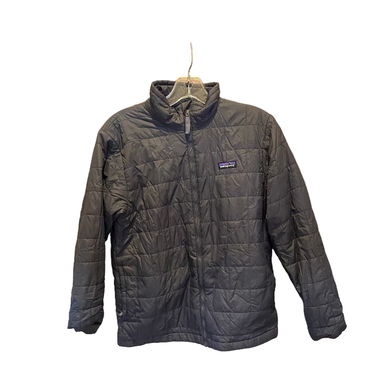Black quilted jacket on a hanger against a wooden panel background