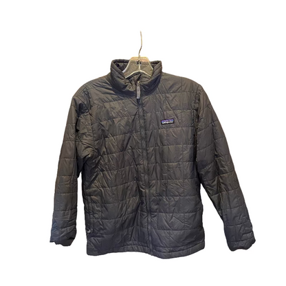 Black quilted jacket on a hanger against a wooden panel background