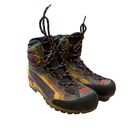 Pair of hiking boots on a wooden floor with a store in the background