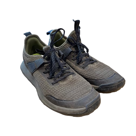 Pair of brown sneakers on a wooden floor with a store background