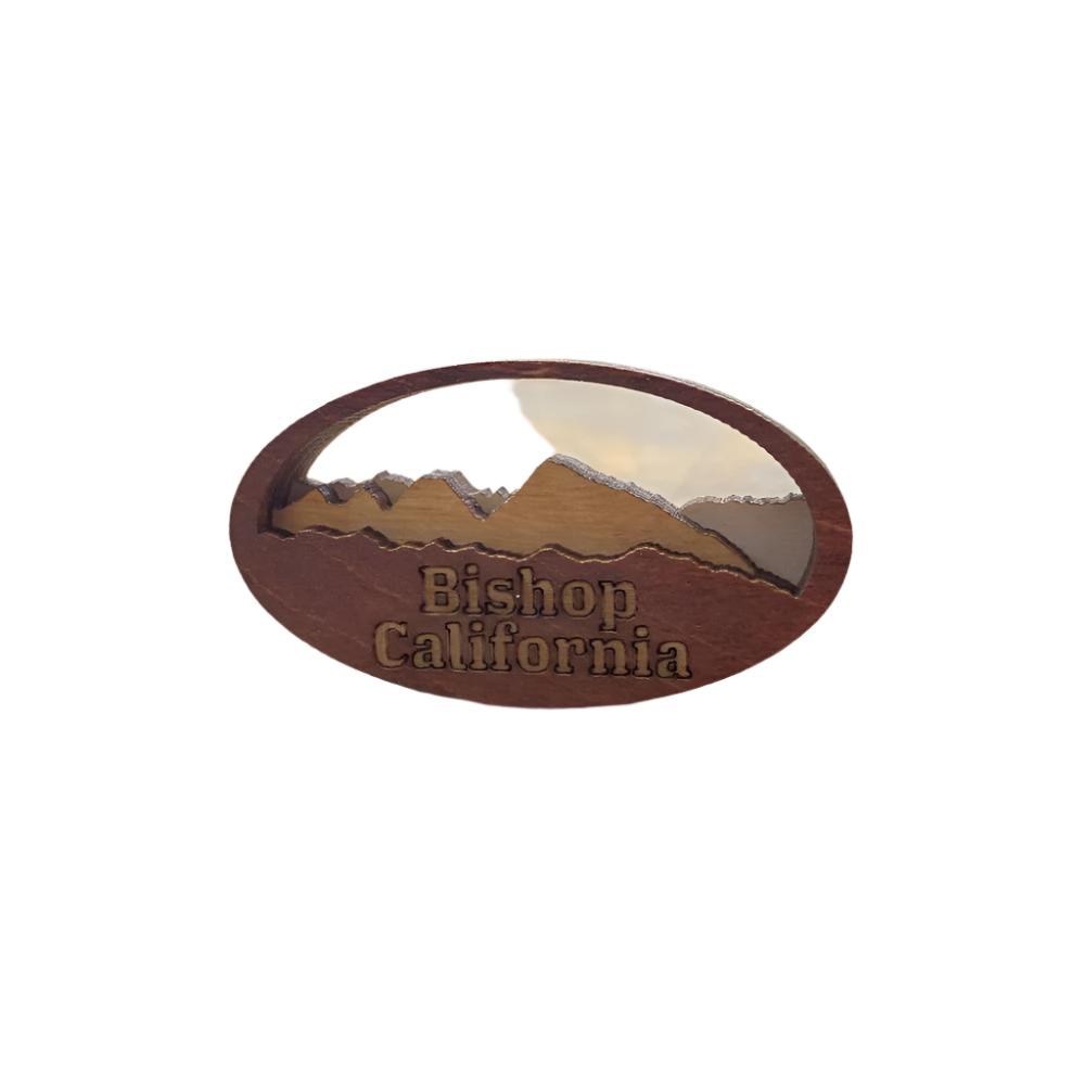 a wooden oval shaped magnet with a mountain silhouette and the words &quot;Bishop California&quot;