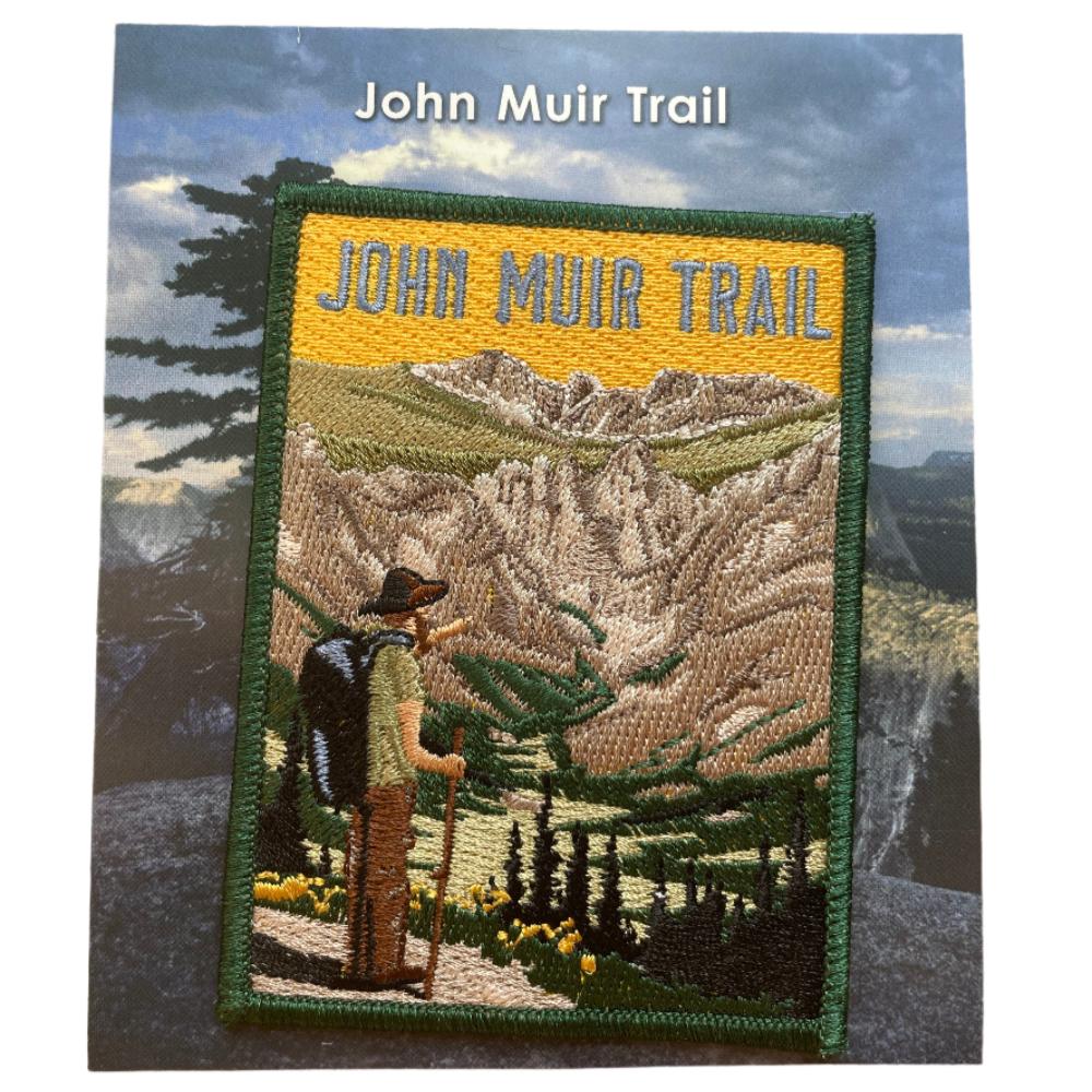 A patch for the John Muir Trail depicting a hiker with a backpack pointing into the mountain scenery.