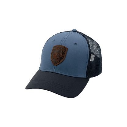 Blue and navy trucker hat with a leather patch and mesh back panels.