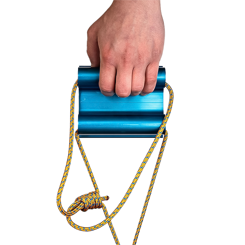 A person gripping a blue Lattice Quad Block with yellow rope, demonstrating strength training for climbing.