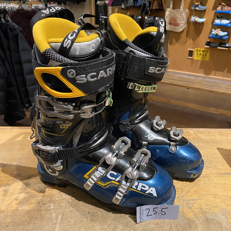 Pair of Scarpa ski boots on display with a price tag in a store setting.