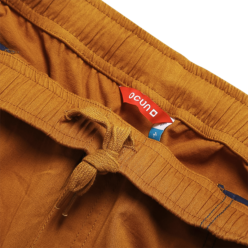 Lightweight light brown climbing pants with ergonomic design, deep pockets, and elastic waistband.