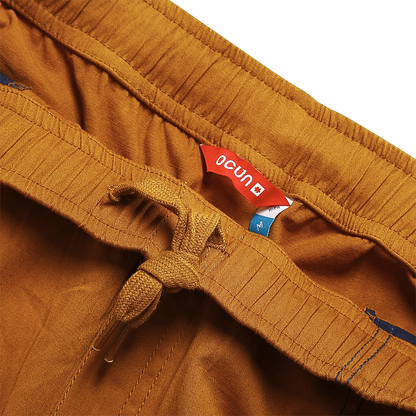 Lightweight light brown climbing pants with ergonomic design, deep pockets, and elastic waistband.