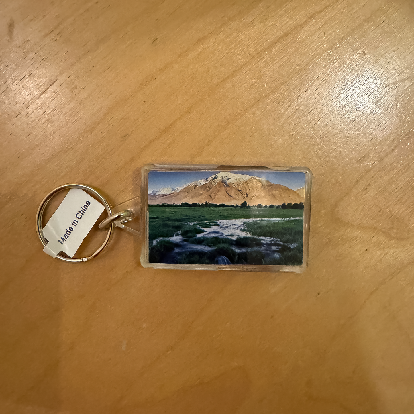 Bishop keychain displaying a sunrise over Mt. Tom and a functional thermometer, great for outdoor adventures.