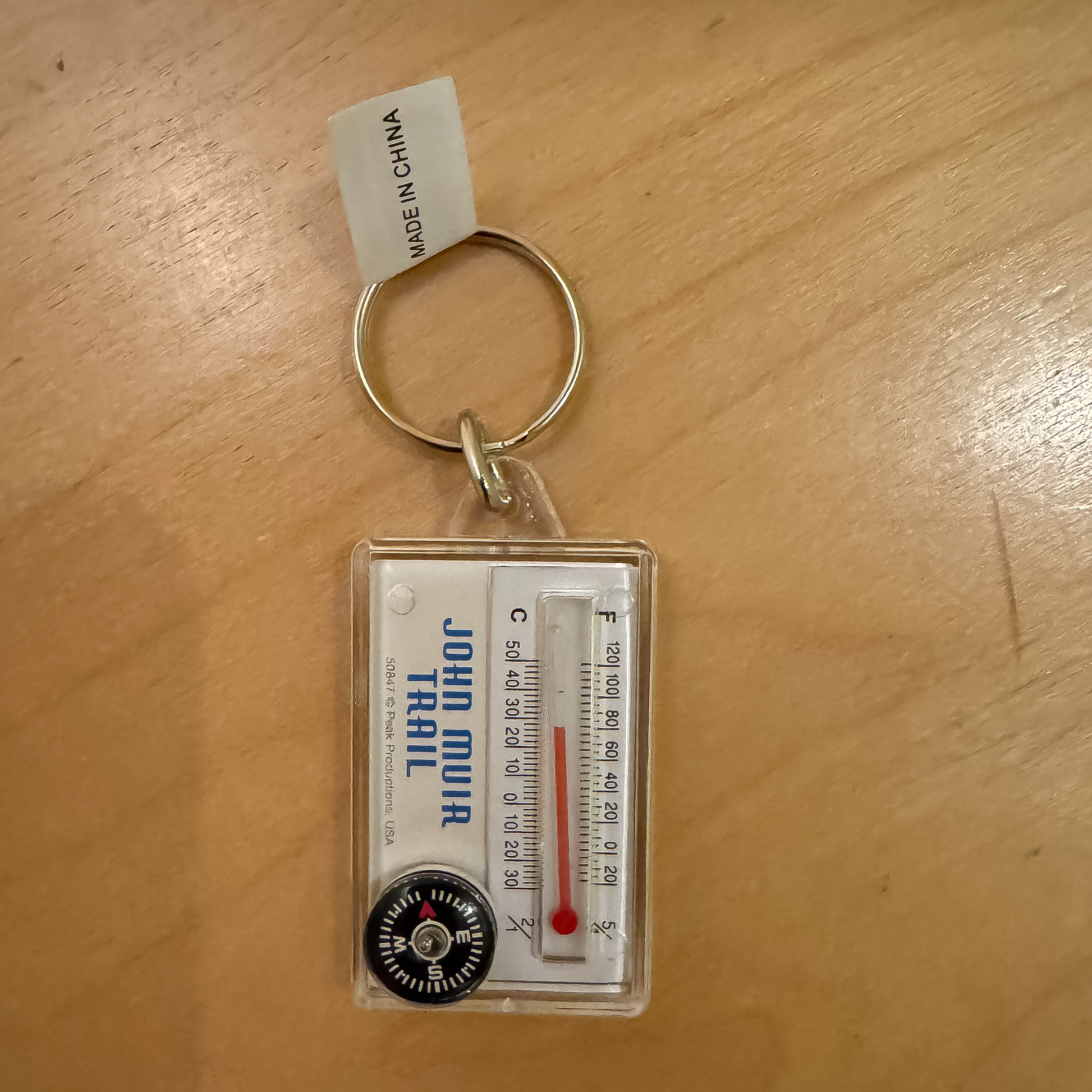 Keychain featuring a mountain range design, compass, and thermometer, inspired by the John Muir Trail for outdoor enthusiasts.