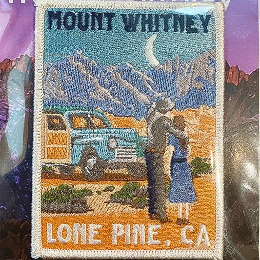 Vintage patch of Mount Whitney showing a couple, a classic car, and colorful desert flora.