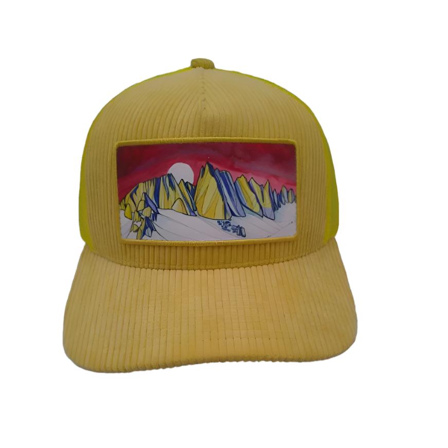 The image showcases the Mammoth Skyline Corduroy Trucker Hat, featuring its khaki color top and undervisor, gold front panel, navy undervisor, and the unique patch design of the Minerats of Mammoth Lakes by Alex Bailey Art.