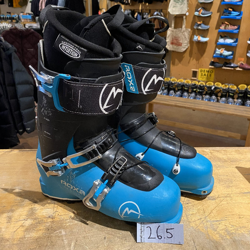 Pair of blue and black ski boots with Roxy branding on a wooden floor.