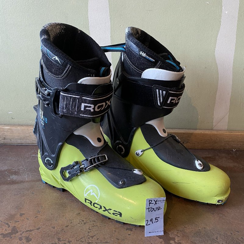 Pair of Roxa ski boots with a price tag on a wooden floor.