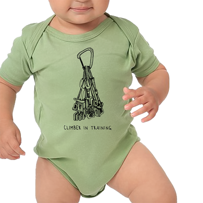 Baby dressed in a green bodysuit with a climbing equipment print with climbing in training, showcasing future potential.