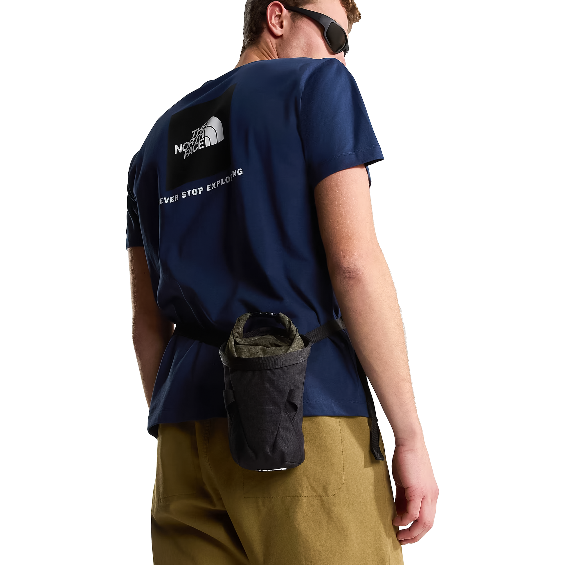A man wearing The North Face shirt and black chalk bag on a white background.
