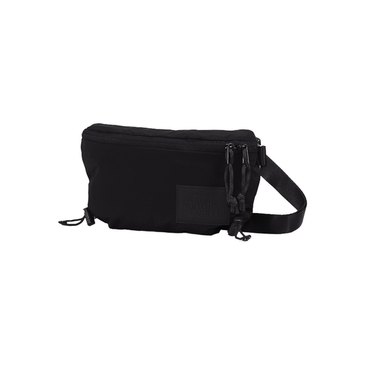 Black North Face waist bag with front zipper, made from recycled nylon, for urban and outdoor use.