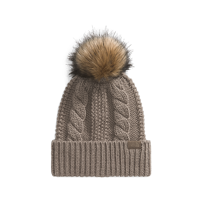 Brown eco-friendly women's beanie with thick cable knit and oversized faux fur pom, made from recycled fabric.