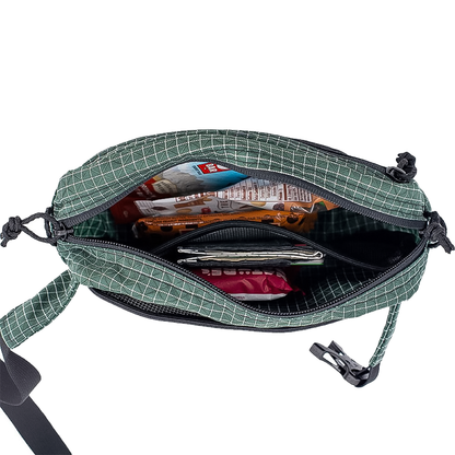 Green and black checked ULA waist pack with zipper and multiple compartments for hikers. 