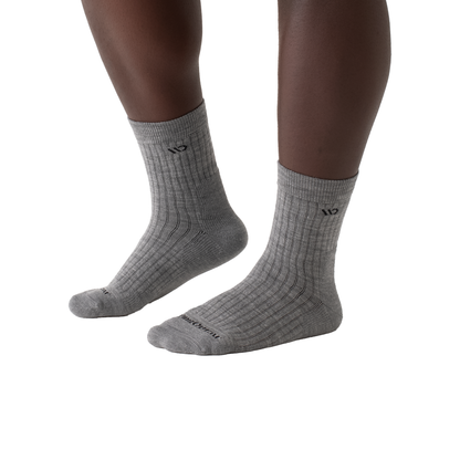 Close-up of legs in grey cushioned socks, highlighting their stretchy fit and soft Merino wool blend for all-day comfort.