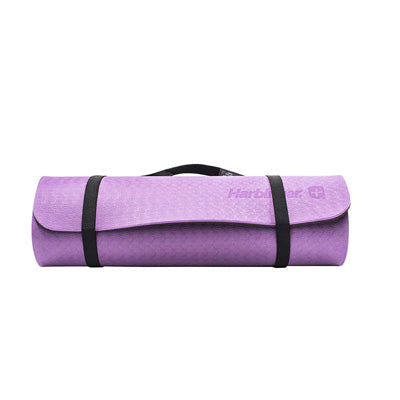 A purple colored exercise mat rolled up with a black shoulder strap, on a white background. 