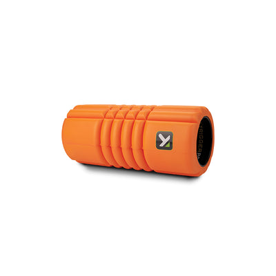 The TriggerPoint Grid Travel is an orange portable foam roller with a textured surface that mimics the hands of a massage therapist.
