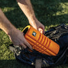 The TriggerPoint Grid Travel is shown in vibrant orange, compact and easy to carry.